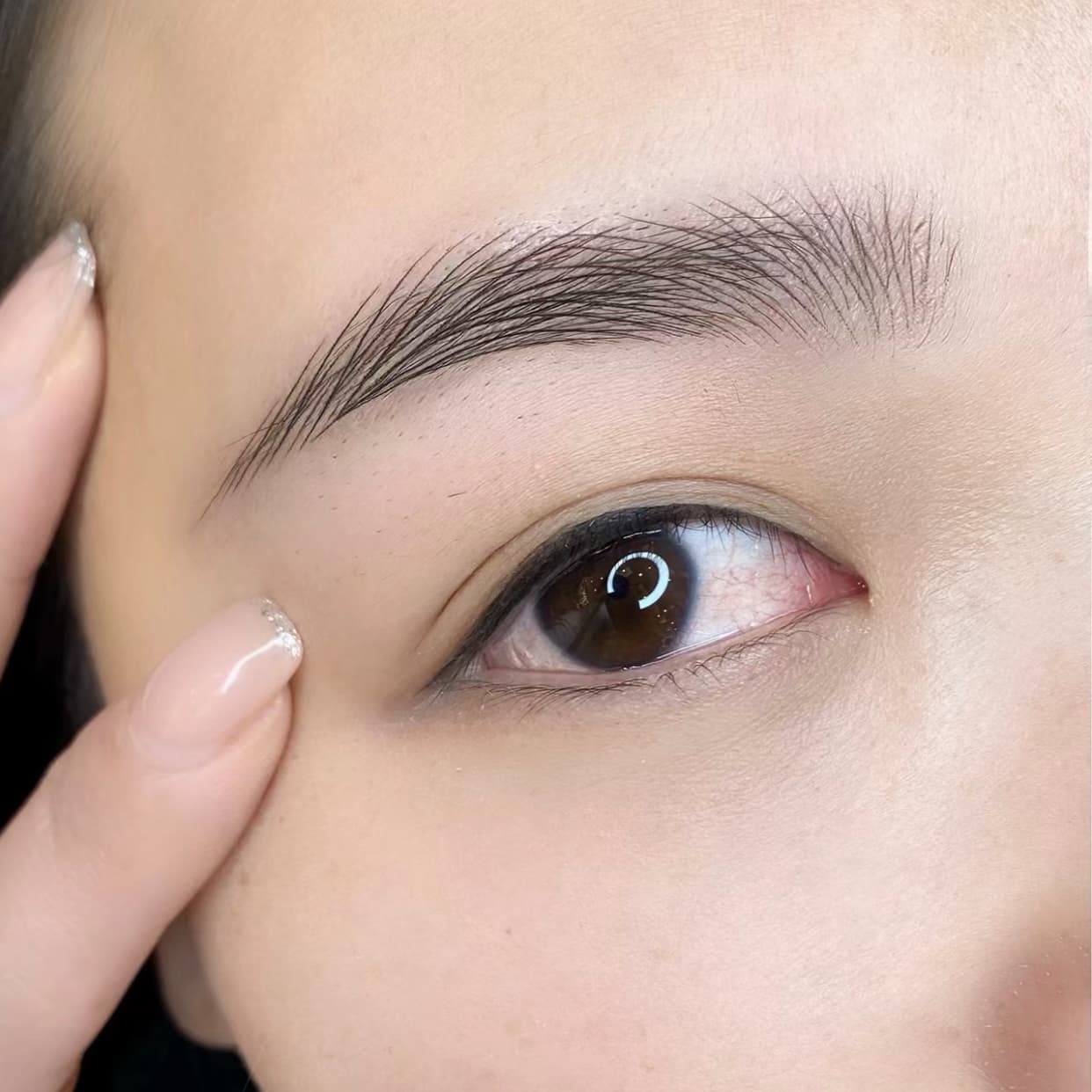 Close-up of a client's brow and eye during inner eyeliner application