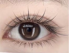 Close-up of a hybrid lash extension set combining singles and volume fans